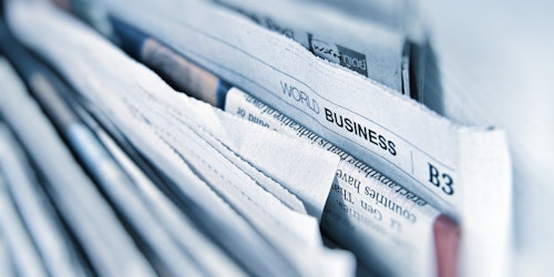 Some newspapers, stacked vertically, spine-up