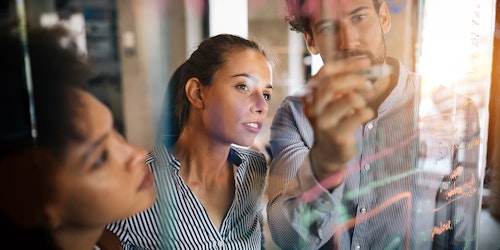 2 women and a man standing in front of a clear whiteboard