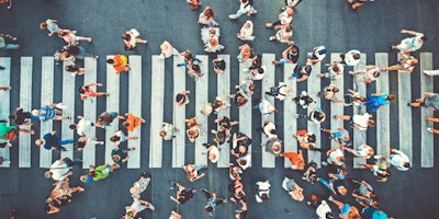 People, crossing a pedestrian cross, representing audience targeting with digital out of home