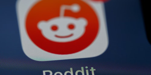 The Reddit logo, on a phone, blurred