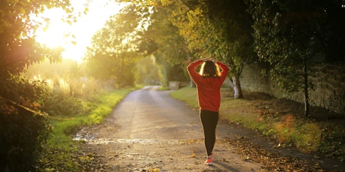 Woman walking on sunny path