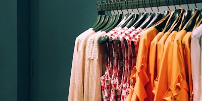 Red and orange clothes on a clothing rail