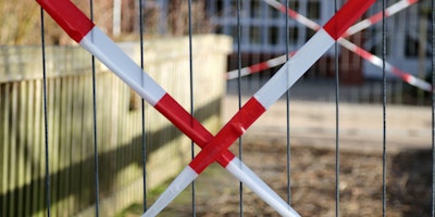 Red 'caution' tape over a gate