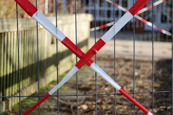 Red 'caution' tape over a gate