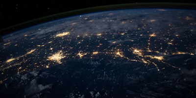 A view of earth from space, its communication networks lit up like cracks in a painted-over lightbulb