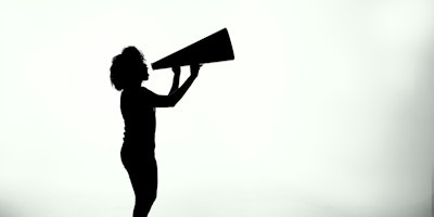 A silhouette of a young person holding a megaphone against a white background