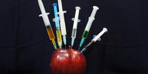 An apple, with syringes in it