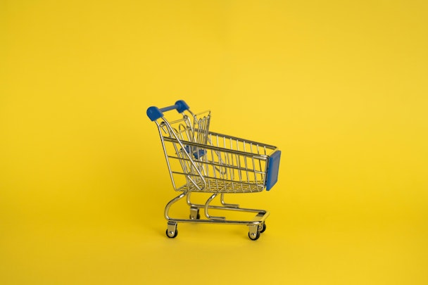 A retail shopping trolley amid a yellow background