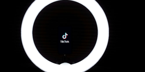 The TikTok logo, lit by a ring light