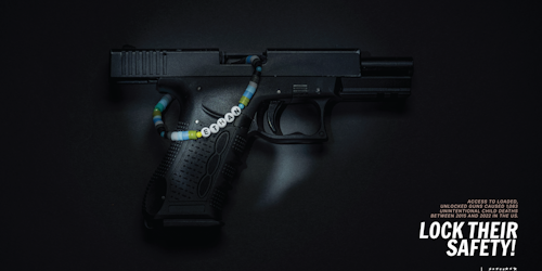 A gun with a beaded bracelet around it 