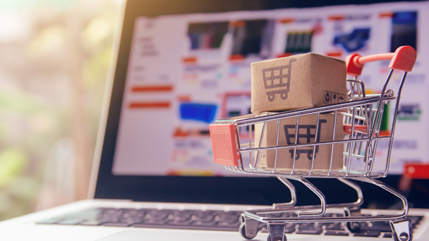 A shopping trolley sitting on a laptop