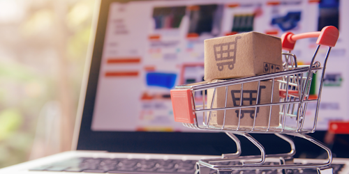 A shopping trolley sitting on a laptop